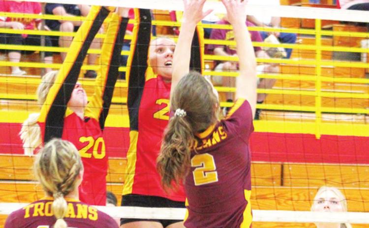 Lady Titan Sophomores, Gracie Major and Katie Simpson get a block at the net against Girard Senior, Kinley Smith, during home matches recently. Senior, Lexy Stone, is ready and awaiting the outcome of the play.