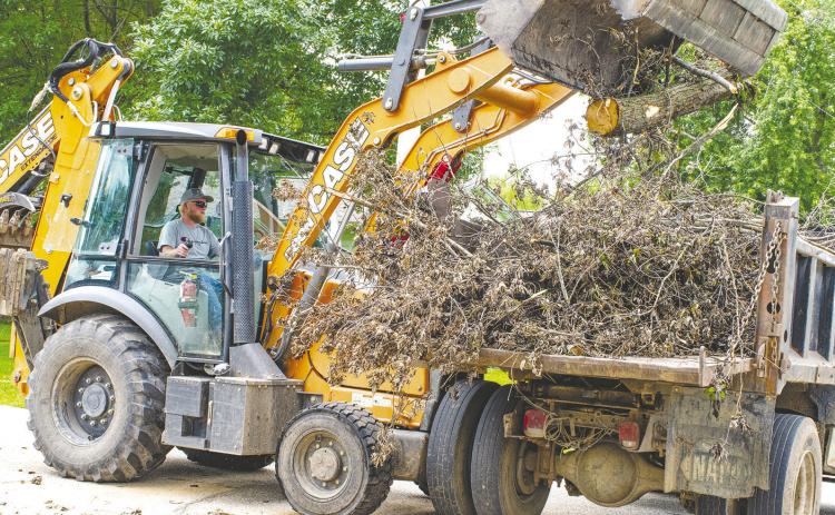 With recent storms, many Columbus residents have seen limb and tree damage accumulate. City equipment operator Levi Thompson places brush in one of several waiting dump trucks as city crews work to pick up debris set out for collection by area residents. The city anticipates running the pickup through the end of the month before crews begin work on road milling in preparation for summer street projects.