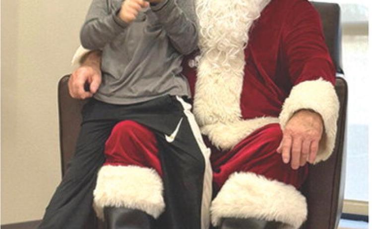 An early visit to Cherokee County by Santa Claus was an opportunity for Jacob Schreiner to share his Christmas wish list. Schreiner and the rest of Suzette Henderson’s Kindergarten class at Park traveled to American Bank Wednesday to meet Jolly St. Nick. Courtesy photo.