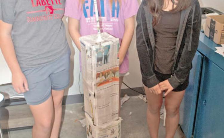 Standing behind their paper tower, Temperance Goff, Grace Alderman and Emily Soto, were first finished with the tower likeness including the antenna. This tower was judged among the best.