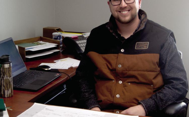 Cherokee County Ag and Natural Resource Agent Clayton Jester sits behind his desk at the K-State Research and Extension office in Columbus.