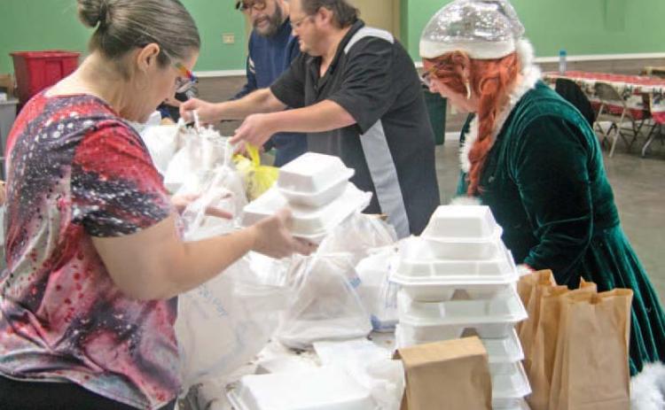Volunteers prepare Christmas dinners for delivery to those unable to attend the Annual Community dinner at the 4-H building.