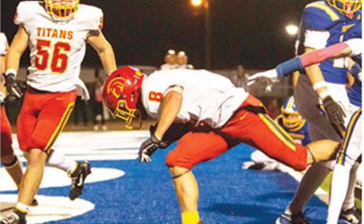 Braun Stone, Titan Senior, punches through the scrimmage line and across the goal line for a one-yard touchdown late in the Columbus win at Iola, Friday night. The Titans came home with a 33-21 win over the Mustangs with the help of Stone’s three rushing touchdowns. Teammate, Kash Smith, junior, met him in the end zone. Photo by Kristin Sharp.
