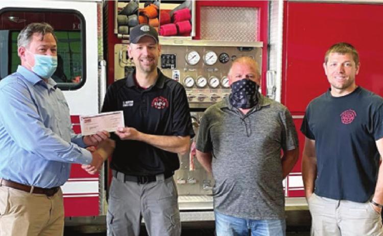 Columbus TAMKO Plant Manager Greg Powell recently presented a check for $1,000 to Columbus Fire Department in recognition of International Fire Fighter’s Day. The donation to four area departments is an expression of gratitude to fire fighters, many who are volunteers. Chief Steven Burton accepted the check for Columbus Fire. Joining him at the presentation were Steven Burton Sr. and Cody Burton. Courtesy photo.