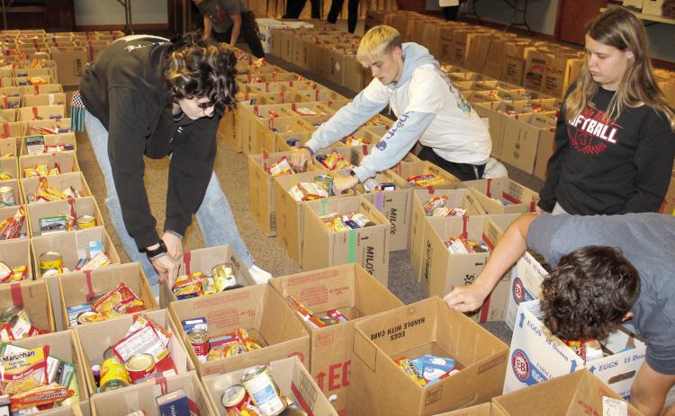 Columbus High School students helped pack over 7,000 items into the food boxes that will be distributed for Thanksgiving. Volunteers make the project a suc-