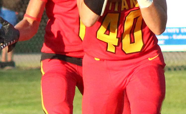 Trojans sneak past Titans in opener