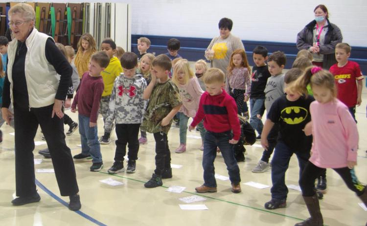 Kindergarten students at Spring Grove Primary School in Galena celebrate Kansas Day with retired teacher Nancy Bash. The group dances to the “Hokey Pokey” after learning about the state’s official animals, crops and singing “Home on the Range” together. Photo by Jacob Spencer