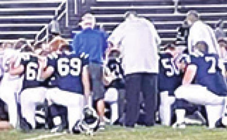 Players and coaches for the Riverton Rams and Galena Bulldogs Football Teams knelt and prayed together for Riverton Head Basketball Coach, Brandon Pate, following their CNC League game in Galena, Friday. Coach Pate’s wife, Paige Christiansen Pate teaches Spanish in both school districts. Galena won the contest, 42-24. Courtesy Photo.