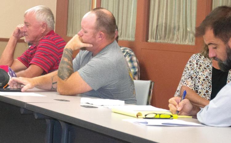 Neosho County Commissioner Paul Westoff talks with Cherokee County Commissioner Cory Moates about the wind farms which have been seeking property in Cherokee County. The commissioners are expected to pass a resolution to establish a moratorium on wind farms.