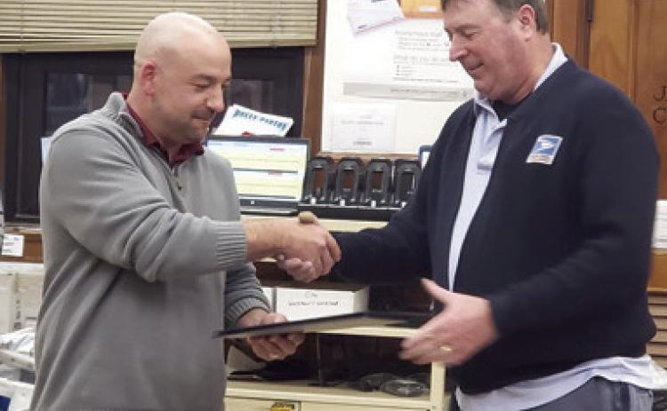 Columbus Post Master Tyler Speer presented long time postal carrier Patrick Billesbach with a certificate recognizing his years of service and celebrating his retirement. Billesbach has worked in Pittsburg as well as here in Columbus. Billesbach began as a mail clerk before taking a carrier position. Courtesy photo.