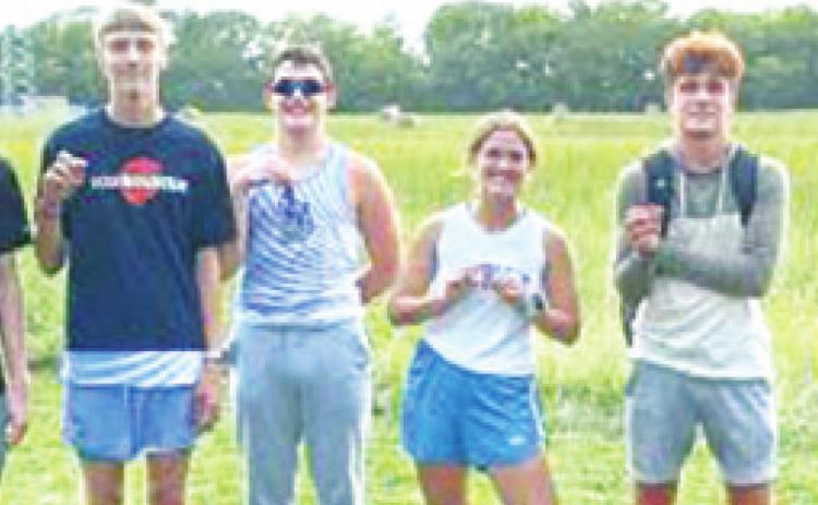 Members of the Lancer Cross Country Team medaling at Girard, Thursday, with Coach Laney Lawson are: junior, Logan Bois; junior, John Turpen; junior, Dakota Smith; junior, Audrey Jacobs; junior, Drake Guyman; freshman, Colton Jameson; and junior, Easton Renn. Courtesy Photo.