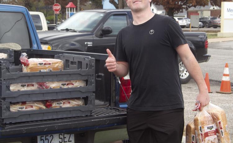 Jett Tanner was one of the Columbus High School students passing out food for the Thanksgiving boxes. Lines for the boxes were long and lined up several blocks from the pick up location. News Report photo by Shawn Churchill.