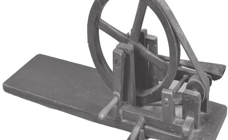 This 19th century apple peeler, painted green, has a flat plank base and a crank handle. It sold for $649. This early apple peeler is very rare because of the fragile all-wood construction.