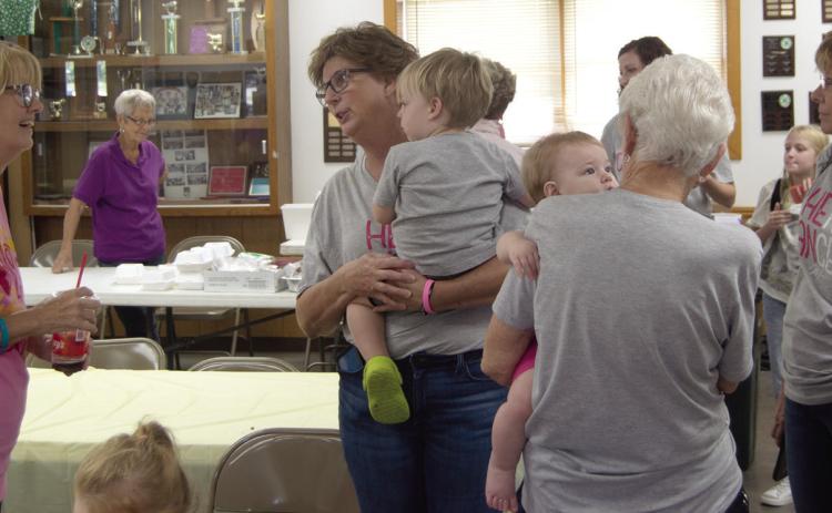 Friends and family of Traci Spear (holding grandson James Hodgson) attended the pulled pork fundraiser held at the 4-H Building September 28. Proceeds will go for treatment and travel expenses.