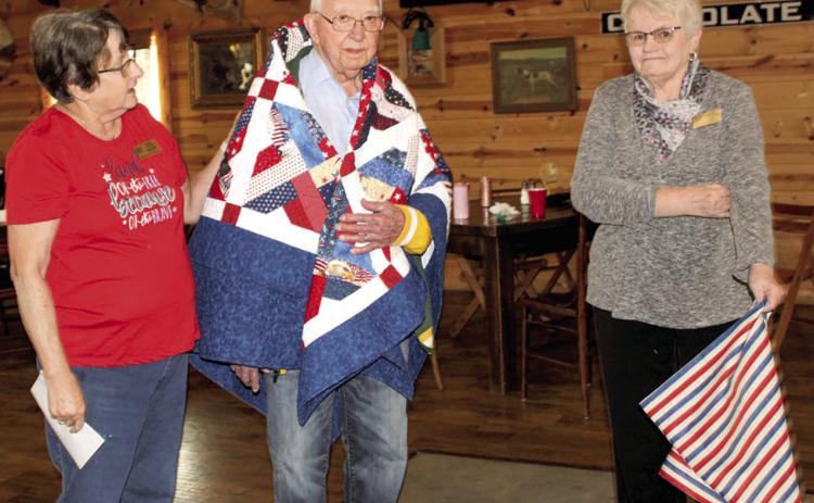 George Kasten (center) was recently honored with an early 90th birthday party. While his birthday is in December, the party was held early so his family in Wisconsin could be present. Kasten was also presented with a Quilt of Valor for his military service at the party. Kathy Lunday and Janie Fletcher presented the quilt.
