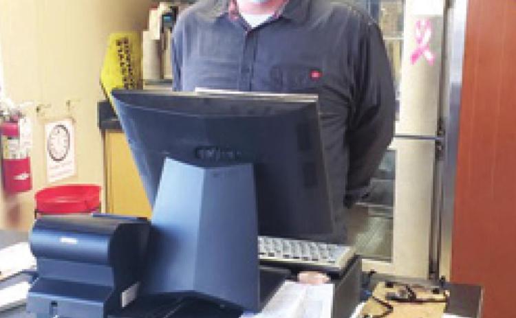 Tyson Coombes, manager at the Baxter Springs Pizza Hut, is behind the register ready to serve the community members hungry for pizza.