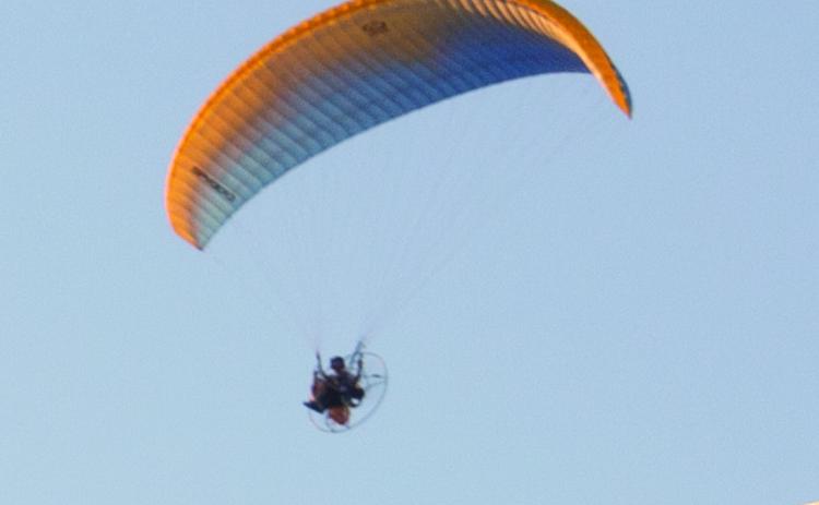 Several years ago seeing a powerchute in the skies over Columbus was not unusual, since they were manufactured here. However in today’s world they are seldom seen, Tuesday evening this powerchute was travelling south near Highway 7.