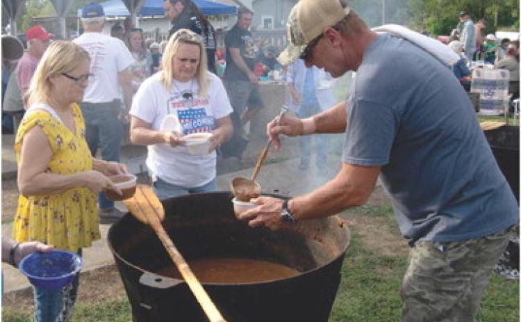Junior Collingsworth dips chili from the large caldron Friday evening as the Weir Homecoming got underway. The free chili and beans cooked all day over a wooden fire. Several hundred people were served at the event.