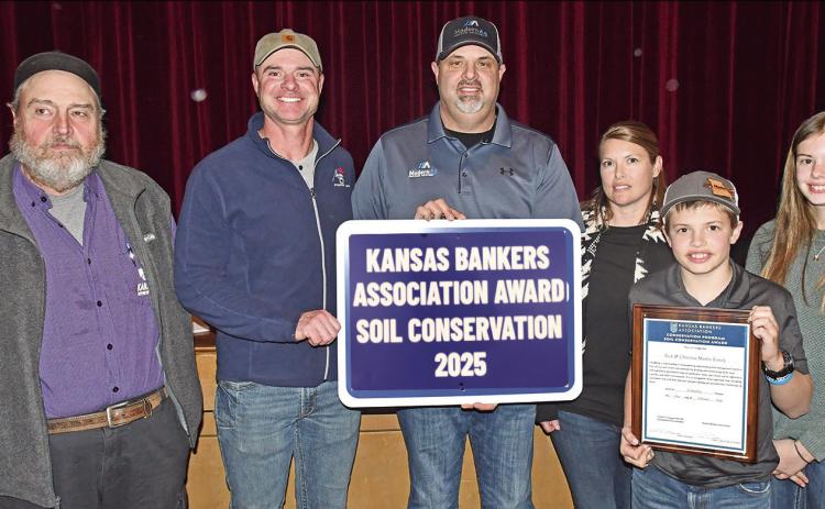 At the Soil and Water Conservation meeting Monday, Nick and Christina Martin and their children Karsten and Kate were presented with the 2025 Kansas Bankers Association Award for Soil Conservation. Mark Epler and Jim Gaither presented the award.