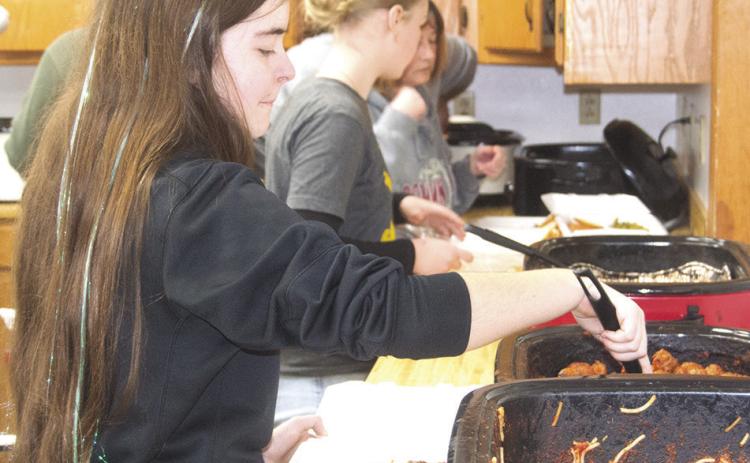 During the recent spaghetti dinner fundraiser for Eva Maxton, Kora Welch was helping out in the kitchen. She was boxing up spaghetti and meatballs for those attending. News Report photo by Shawn Churchill.