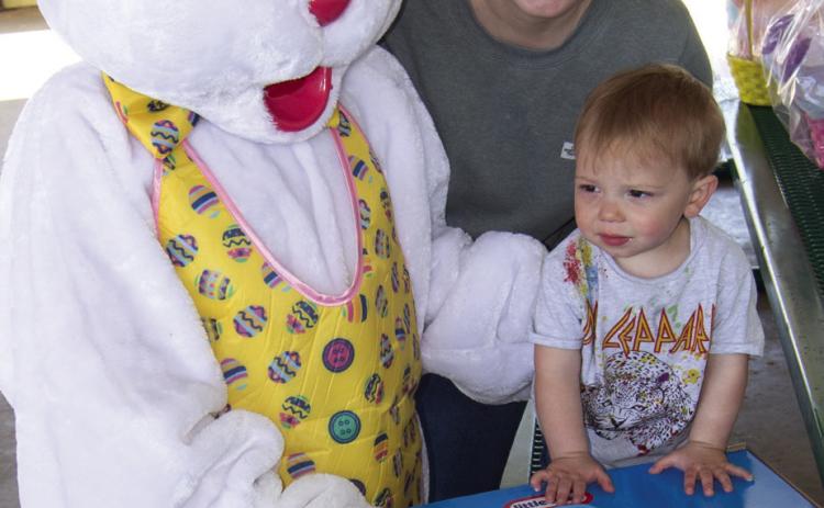 Eighteen month old Luca Knight, of Olathe, held by his mother Paige as the Easter Bunny presents him with a roll-around trike following the Columbus Chamber of Commerce Easter Egg Hunt on Saturday. He won in the under two years old division.