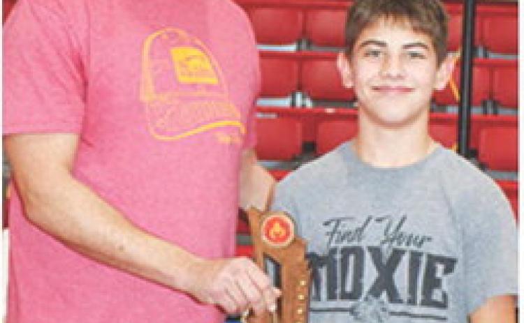 Blaze Bowman receives his Outstanding Wrestler Trophy from Clint Saporito during award presentations at the Sixth Annual Ken Jones Classic Wrestling Tournament hosted by the Columbus Wrestling Club, December 22, at the CUHS Gymnasium. Blaze was also the winner of the 14U, 105-110 pound weight class in the tournament.