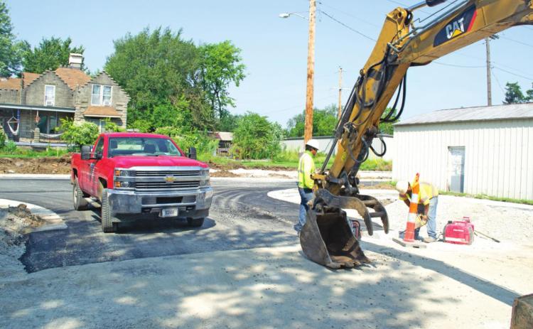 Workmen cut the cement curbing