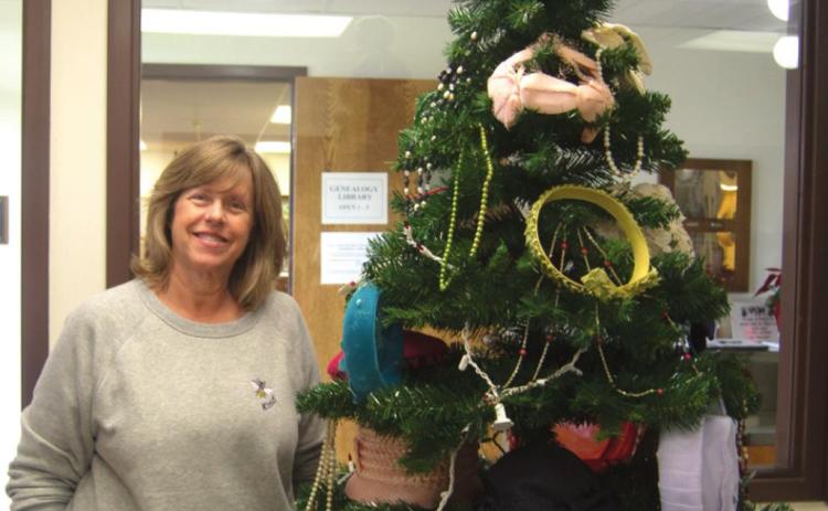 Various hats, caps, crowns and tiaras were adorned all over the Columbus Museum’s Christmas tree for the month of May. The location’s workers make specific efforts to decorate the tree in unique ways each and every month. Patti Street shows off one of its decorative sides. Photo by Jacob Spencer