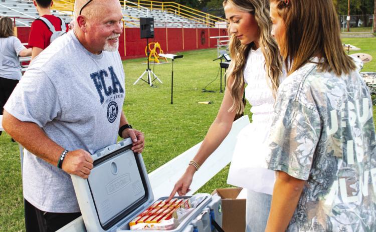 Columbus Fellowship of Christian Athletes leader David Eddington explains to seniors Faith Williams and Tatum Kirk the plan behind the frozen pizzas used in an Ultimate Frisbee Competition as part of the FCA’s Annual kickoff event on Wednesday, September 16.