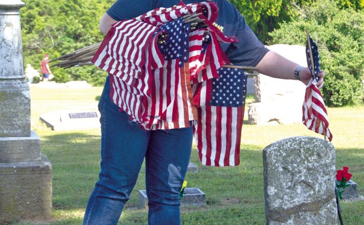 Friday afternoon the Welch family spent the afternoon putting American Flags on veterans graves at both the Park and Columbus cemeteries. Crystal is shown planting flags in the Columbus Cemetery.