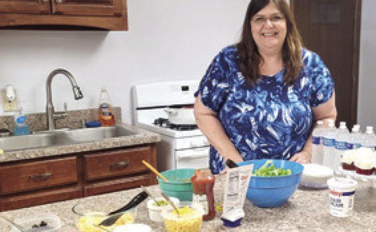 County 4-H Extension Agent Valori Stone stands behind the table at her going away party on Thursday. Stone will be taking a new position with the Wildcat District Extension Office in Fredonia.