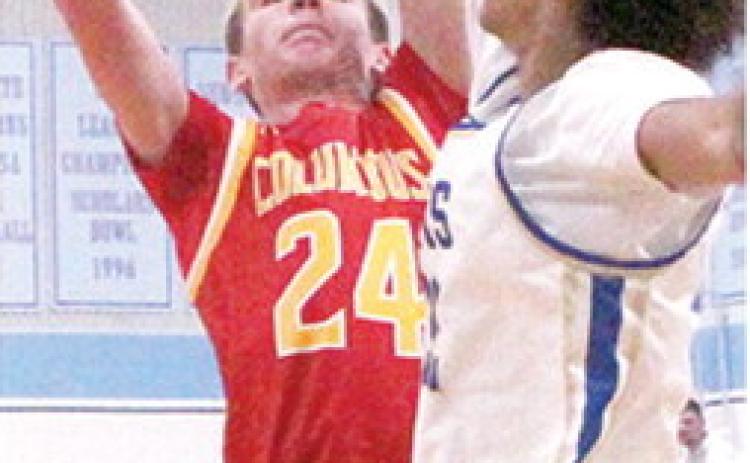 Kooper Saiz, Titan Sophomore, goes up against a towering, Terryk Richardson, Riverton Senior, on his way to scoring 17 points for Columbus in their first round Lancer Classic loss, Monday, in Cherokee.