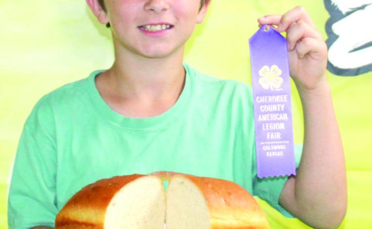 Hunter Davis shows his purple ribbon and his loaf of bread he entered into the Cherokee County foods show.