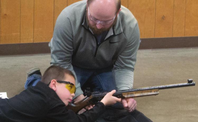 Columbus 4H Club BB Gun Competition Coordinator Dustin Major helps contestant Trevor Lacen to aim his rifle during the Monday, January 17 event. Fifteen local youths competed throughout the afternoon. Photo by Jacob Spencer.