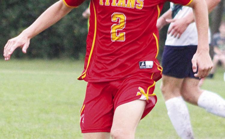Titan Senior, Korbyn Newberry, controls the ball during the varsity soccer match against Liberty Home School, Monday, at the Central School Soccer Pitch.
