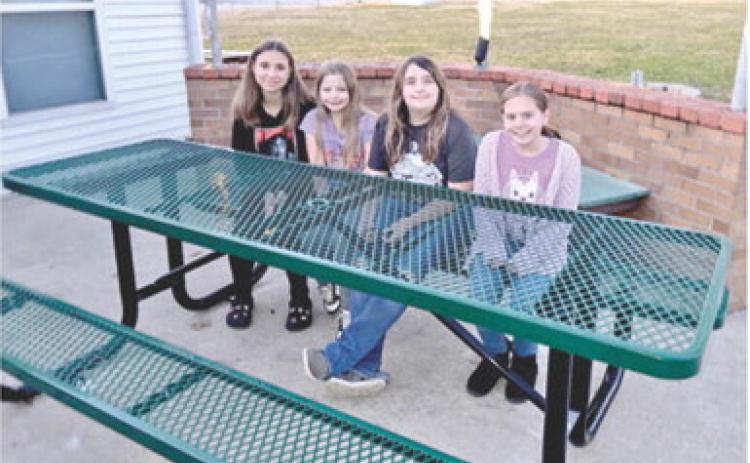 Area Girl Scouts Alyssa Montierth, Lilly Linam, Raygen Spoonemore and Eleanor Holt sit at the new tables installed at the Girl Scout House in Columbus. The tables were made possible by a grant from the SEK Community Foundation. Courtesy photo.
