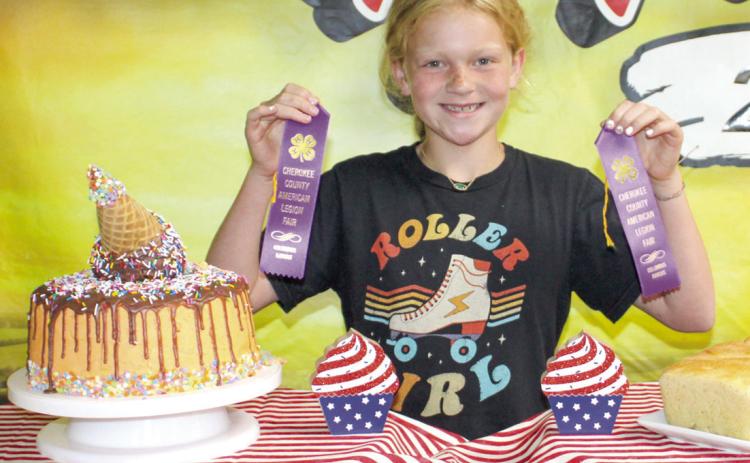 Showing her purple ribbons, Adley Hess made a creatively decorated cake. It looks as if an ice cream cone is melting down the sides, creating the icing.