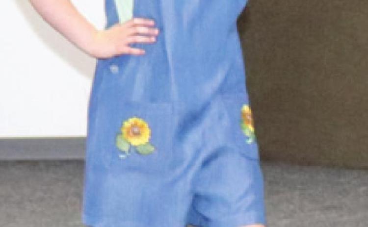 Ryleigh Holmes showed off the denim jumper with embroidered sunflowers on the pockets she sewed during the clothing construction competition. Photo by Amber Helwig.