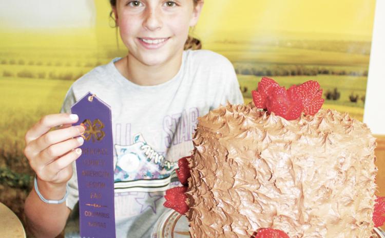 A multiple layer chocolate cake decorated with fresh strawberries earned a purple ribbon for Kinsley Hess at the foods judging. The foods competition was held July 17 in the 4-H Building.