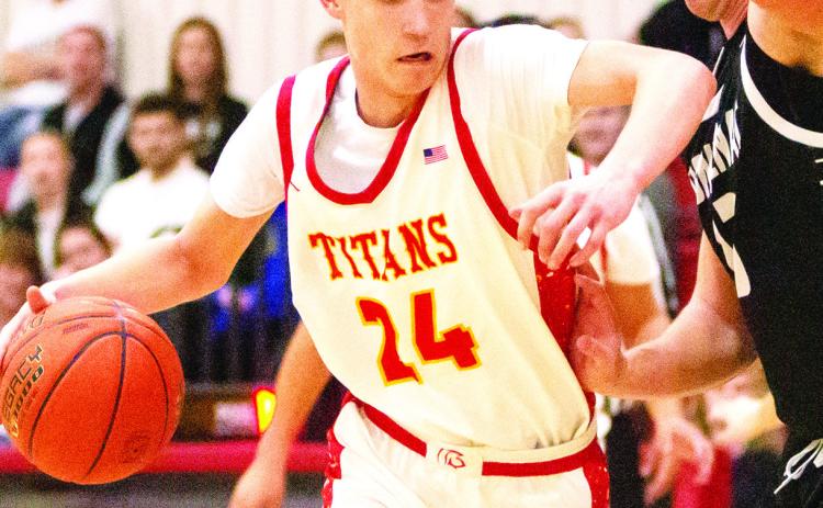 Kooper Saiz, Titan Sophomore, drives to the basket with a little push from his Frontenac defender in the January 31, home loss to the Raiders. The Titans lost a close one, 50-52, against St. Mary’s-Colgan, Friday in Pittsburg. Photo by Kristin Sharp.
