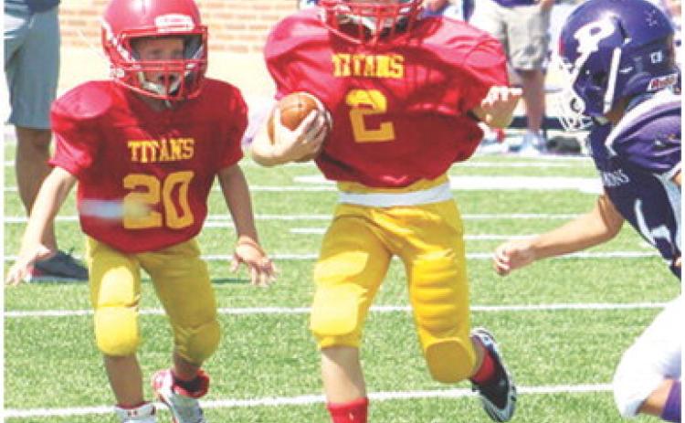 Jaxon Harper eludes a Pittsburg defender on his way to the goal line and into the end zone, Saturday, in the Columbus Mini Titan Third and Fourth Grade win, 26-14, over Pitt Mowen, Saturday at Hutchinson Field in their season opener at Pittsburg. Columbus will host Frontenac tomorrow at Titan Stadium. Kickoff will be at 10 a.m. Frontenac Nelson will be in town for a match up with the Titan Fifth and Sixth Grade Squad. Game time is set for noon.