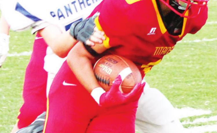 Jayden Rodriguez, Titan Eighth Grader, narrowly escapes the grasp of Panther defender, Charlie Gill, in Thursday’s loss to St. Mary’s-Colgan, 38-8 at Titan Stadium. Kooper Saiz and Jett Tanner can also be seen.