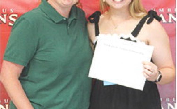 CUHS Assistant Music Director, Christine Lovell, presented the Blanche Combs Scholarship for $100 to Trinity Green at the May 15 Senior Assembly in the Columbus Unified High School Gymnasium.