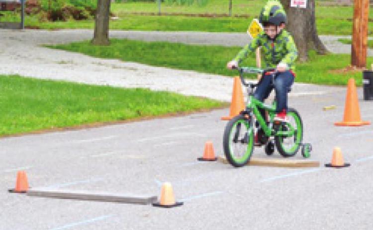 At the recent Lincoln School Bike Rodeo Lincoln Merrill goes over one of the wooden obstacles along the course. Photo by Dee Riley.
