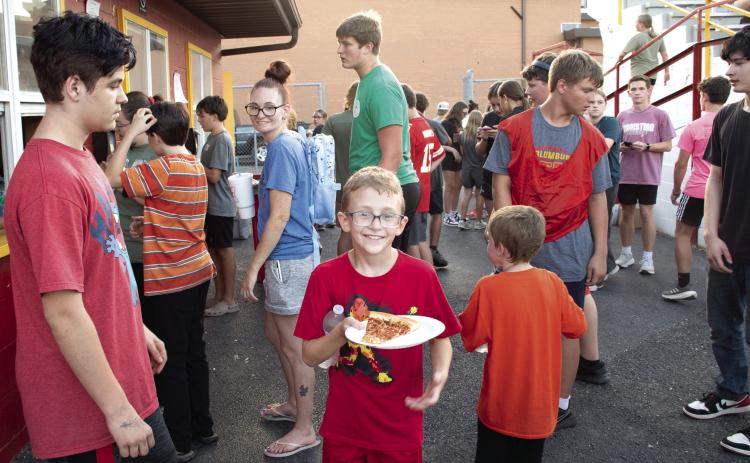 Nothing guarantees a crowd like the offer of free food, the Annual Fellowship of Christian Athletes Kick-Off Event offered free pizza to the more than 100 attendees. An attendee shows off his fresh slice before joining the throng of fellow school kids.