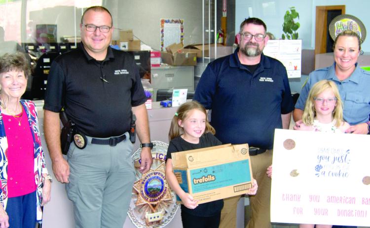 The Baxter Springs Girl Scouts received a helping hand from American Bank as the bank purchased several cases of Girl Scout Cookies which had gone unsold. The girls then delivered the cookies to the Baxter Springs Police Department as a thank-you to the men and women in the department. American Bank vice-president Judy Hill was joined by Girl Scouts Kinley Capps and Sutton Russell as they presented the cookies to Police Chief Brian Henderson, and officers Jimmy Hamilton and Rhanda Andrews.