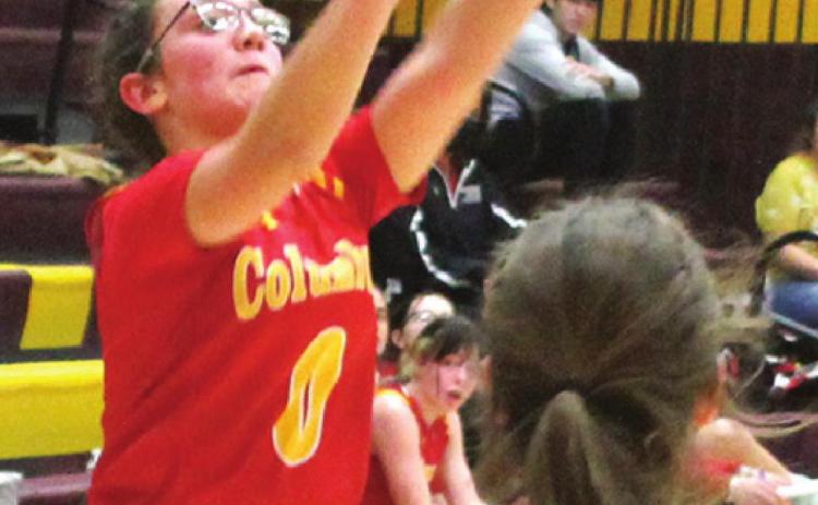 Lady Titan Freshman, Katy Mooney, shoots one of her six, treys to lead Columbus with 21 points in their 52-58, loss to the Lady Trojans in Girard, Tuesday. Senior, Faith Poland defends for Girard.
