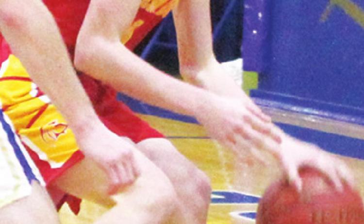 Titan Freshman Jace Midgett, dribbles round his Ram defender in the junior varsity loss at Riverton.