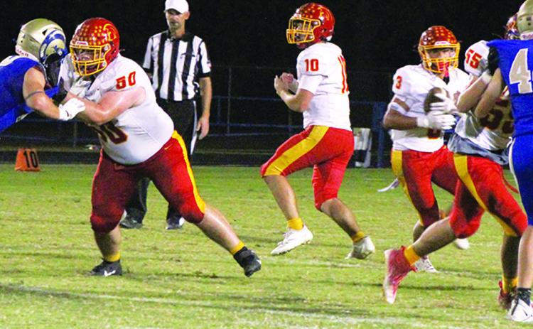 Senior Quarterback, Jack Vilela handed off to junior, Jayden Rodriguez, while seniors, Carter Henry and Jonah Smith make a hole in the line. The Titans took the CNC League win in a 36-0 shutout over the Rams in Riverton, Friday.