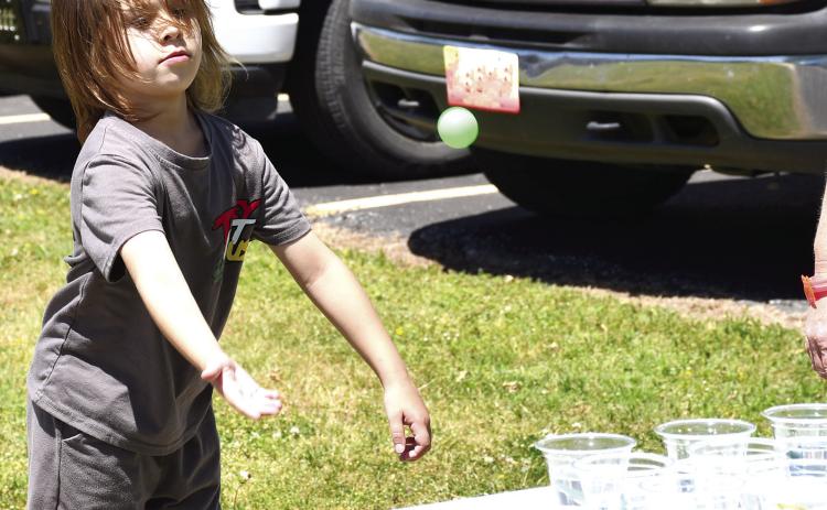 Aiming for one of the small cups, Malco Wilkins tossed his ping pong ball in an effort to win a prize at the Park School carnival held before school let out for the summer.